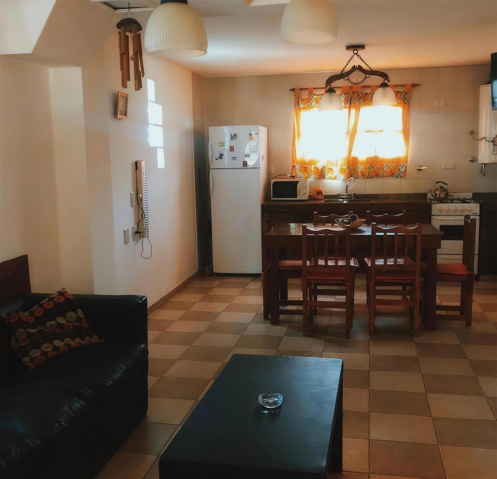 Living comedor del duplex con cocina integrada y mesa de madera para seis
